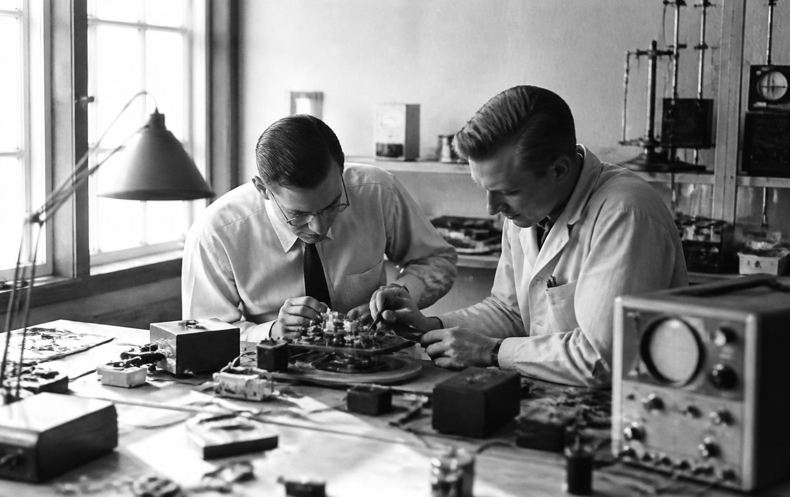 Two engineers assembling instrumentation at a laboratory workbench